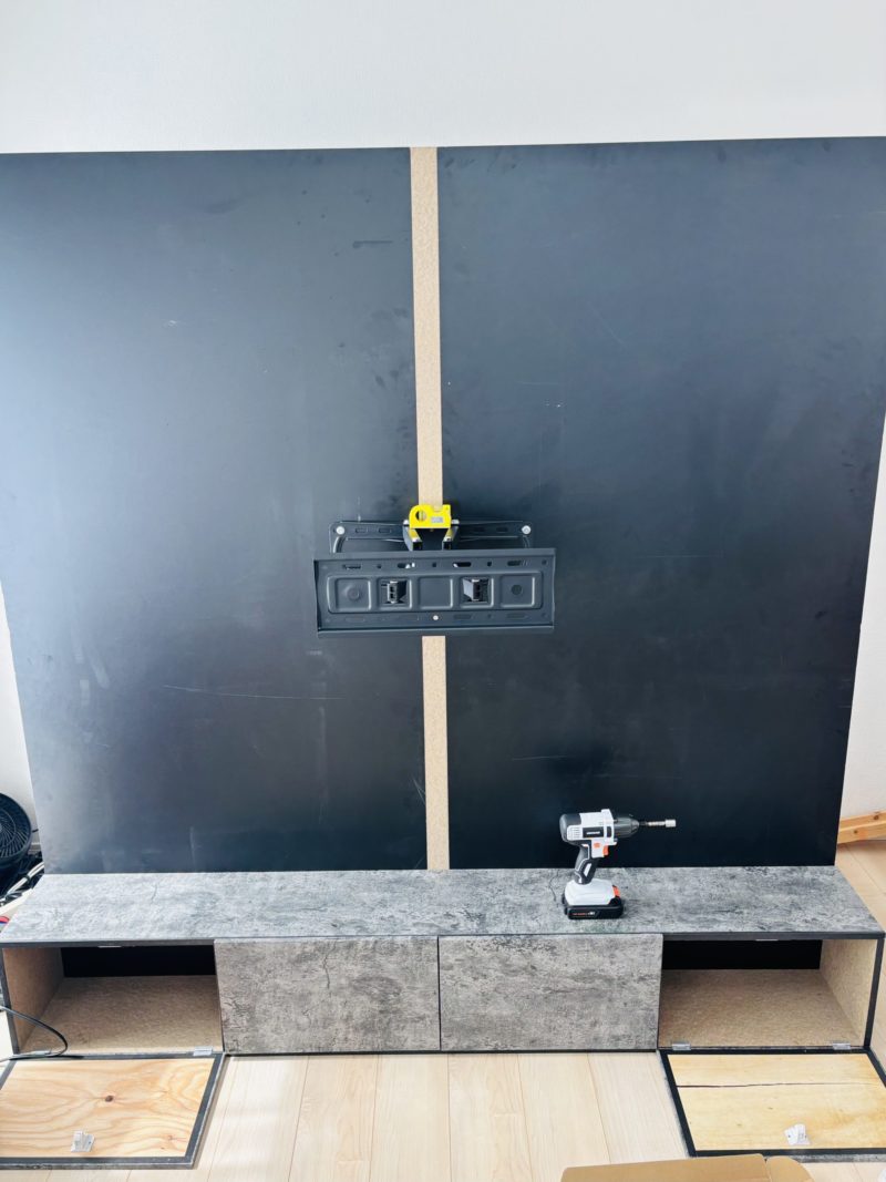 板の中央に壁掛けテレビ用金具を取り付けている写真